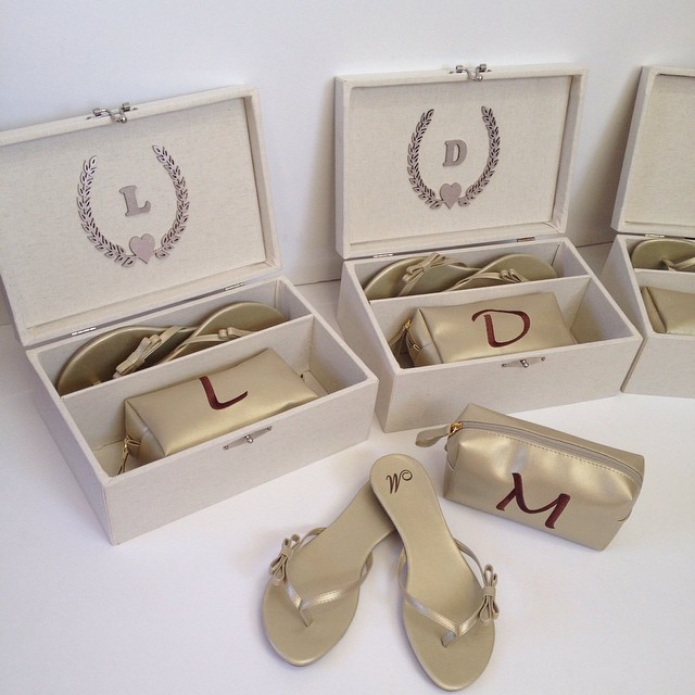 Uma caixa em MDF com sandálias personalizadas e uma necessaire com as inicias da madrinhas. Loja: Bru Puoli.
